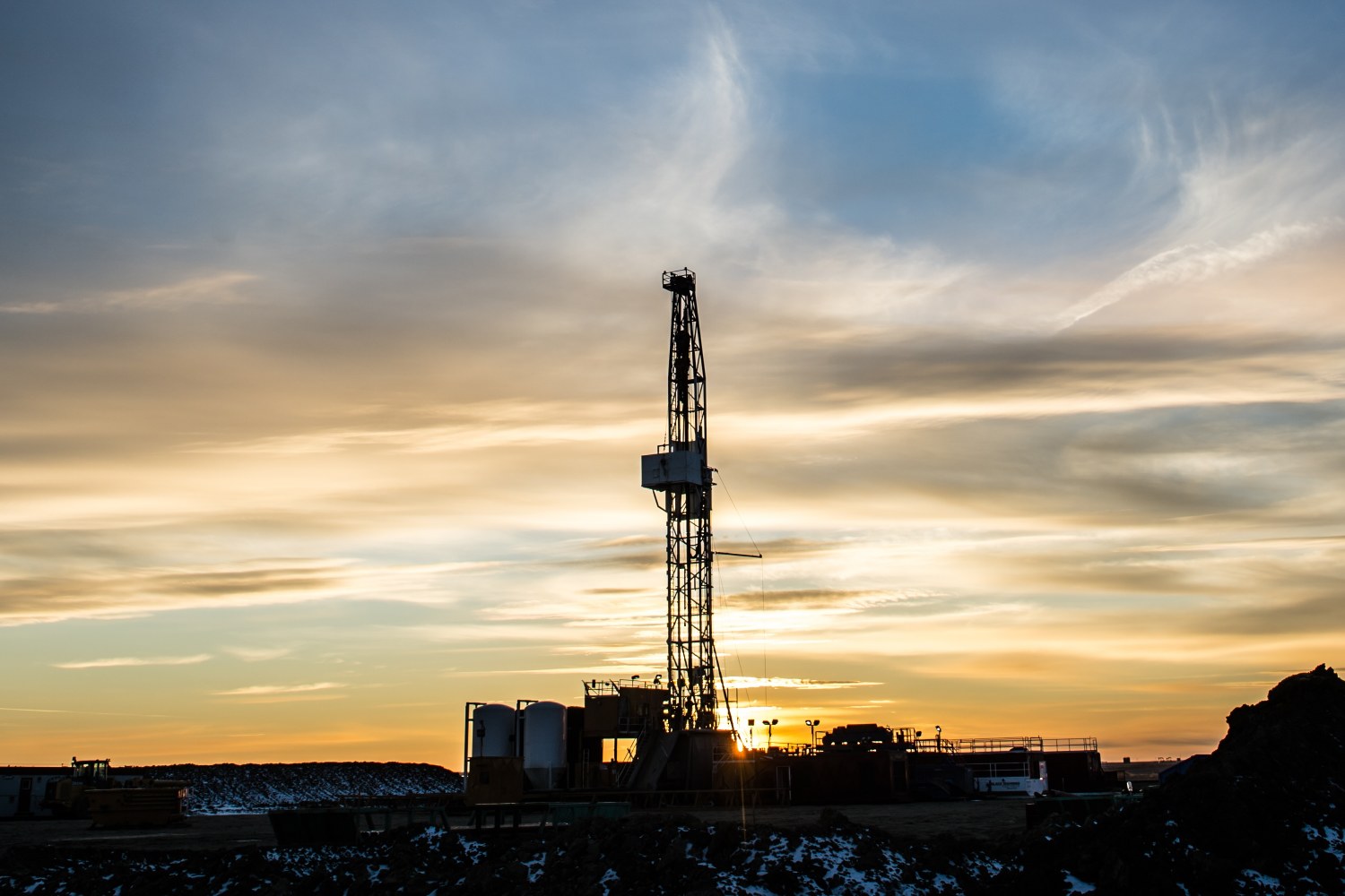 Drilling rig silhouetted against a sunset sky