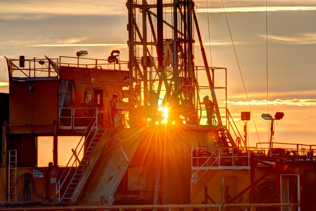 Drilling rig backlit by the setting sun